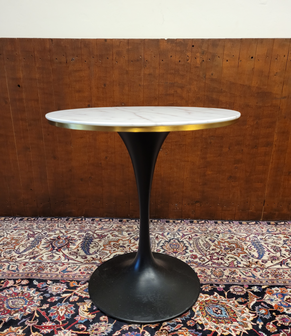 Klassieke-ronde-tafel-gemaakt-van-marmer-met-een-zwarte-metalen-paddestoel-voet