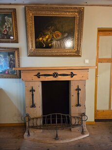 Dekorativer Kamin im Landhausstil mit schmiedeeiserner Feuerstelle